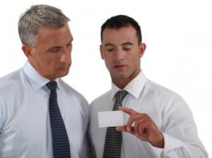 Man looking at business card with friend: SEOLegal Marketing Blog